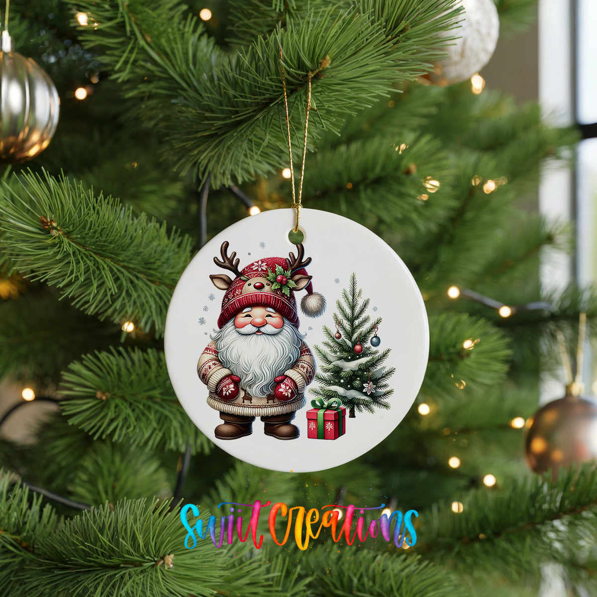 Santa beside a Christmas tree and wrapped gift ceramic Christmas ornament hanging on a green Christmas tree