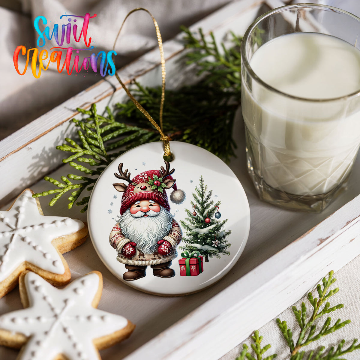 Santa beside a Christmas tree and wrapped gift ceramic Christmas ornament styled with cookies and milk