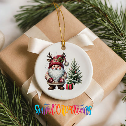 Santa beside a Christmas tree and wrapped gift ceramic Christmas ornament arranged on a wrapped Christmas gift