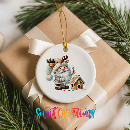 Santa decorating a gingerbread house ceramic Christmas ornament arranged on a wrapped Christmas gift