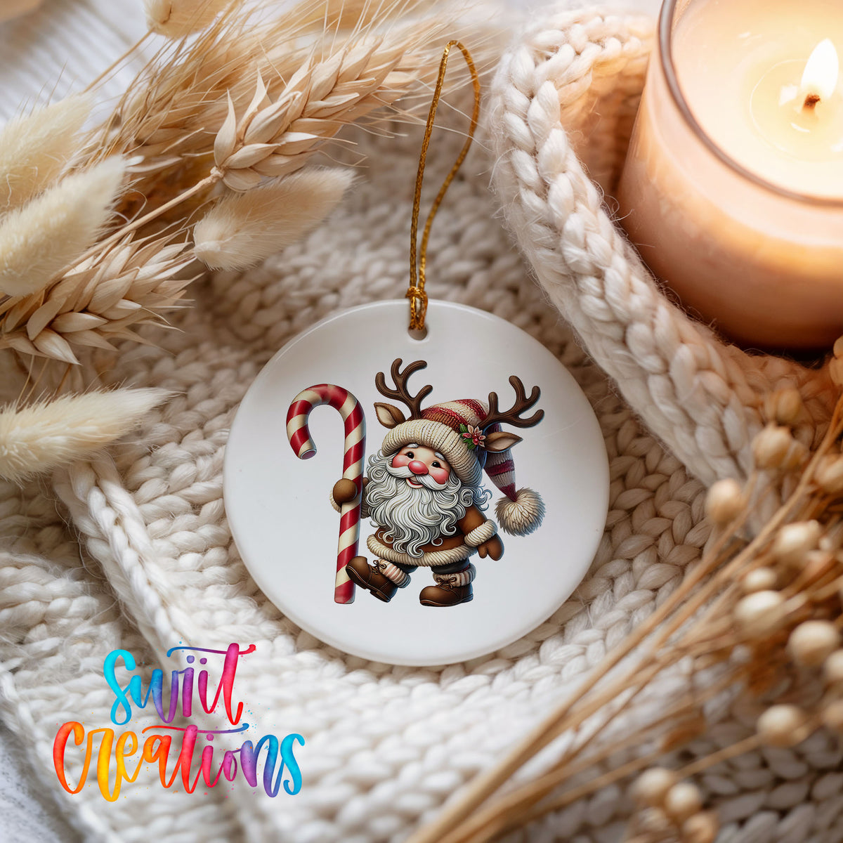 Santa holding an oversized candy cane ceramic Christmas ornament styled beside a candle and cozy knit blanket