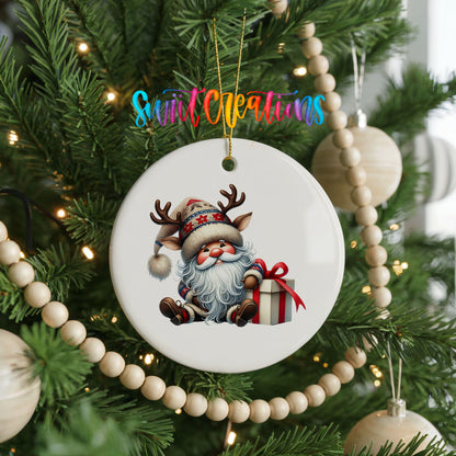 Santa sitting beside a wrapped Christmas gift ceramic Christmas ornament hanging on a decorated Christmas tree