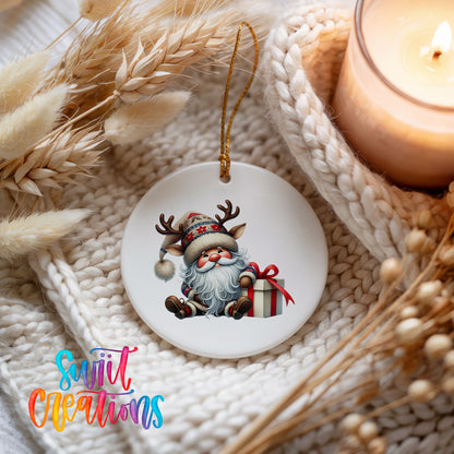 Santa sitting beside a wrapped Christmas gift ceramic Christmas ornament styled beside a candle and cozy knit blanket