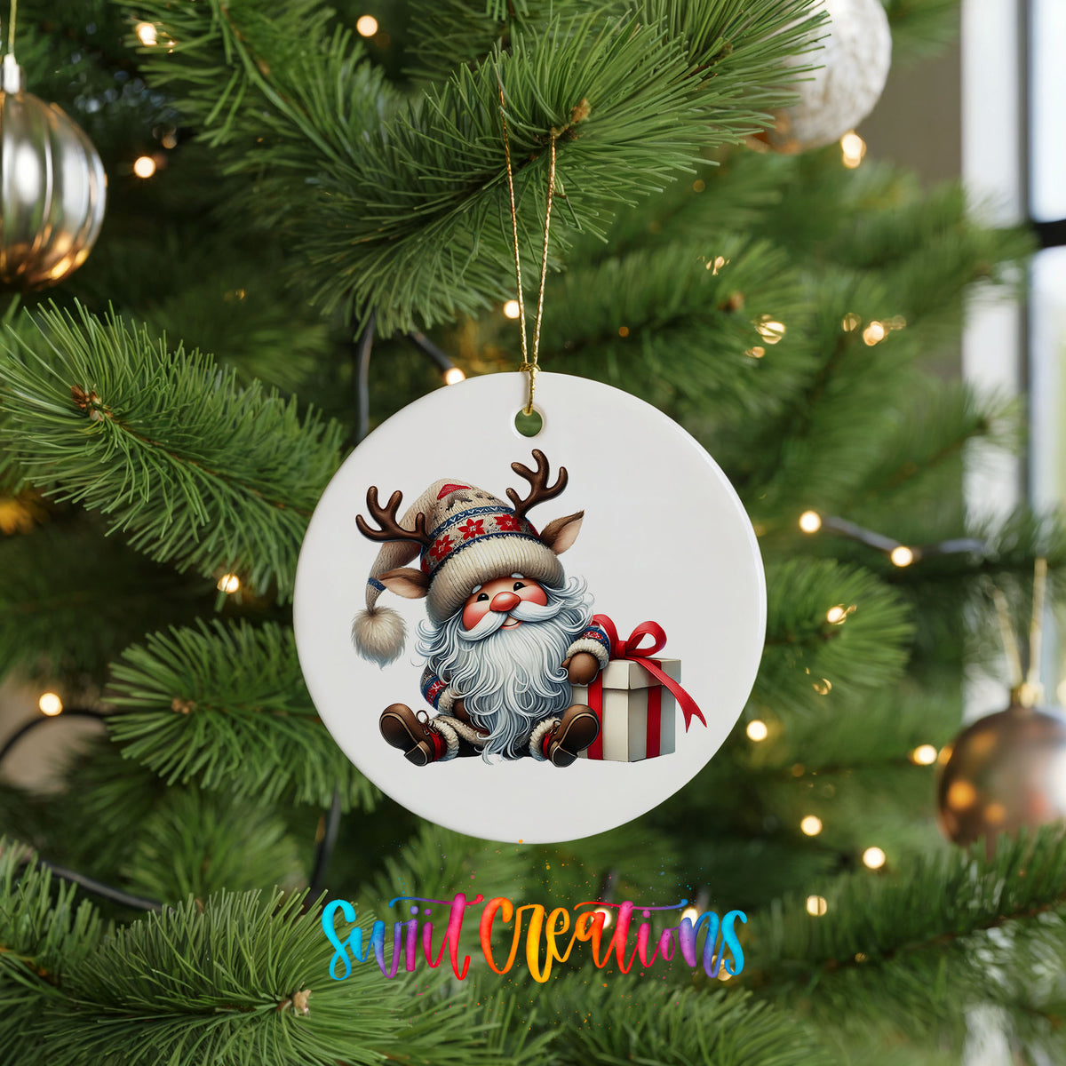 Santa sitting beside a wrapped Christmas gift ceramic Christmas ornament hanging on a green Christmas tree