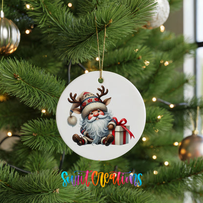 Santa sitting beside a wrapped Christmas gift ceramic Christmas ornament hanging on a green Christmas tree