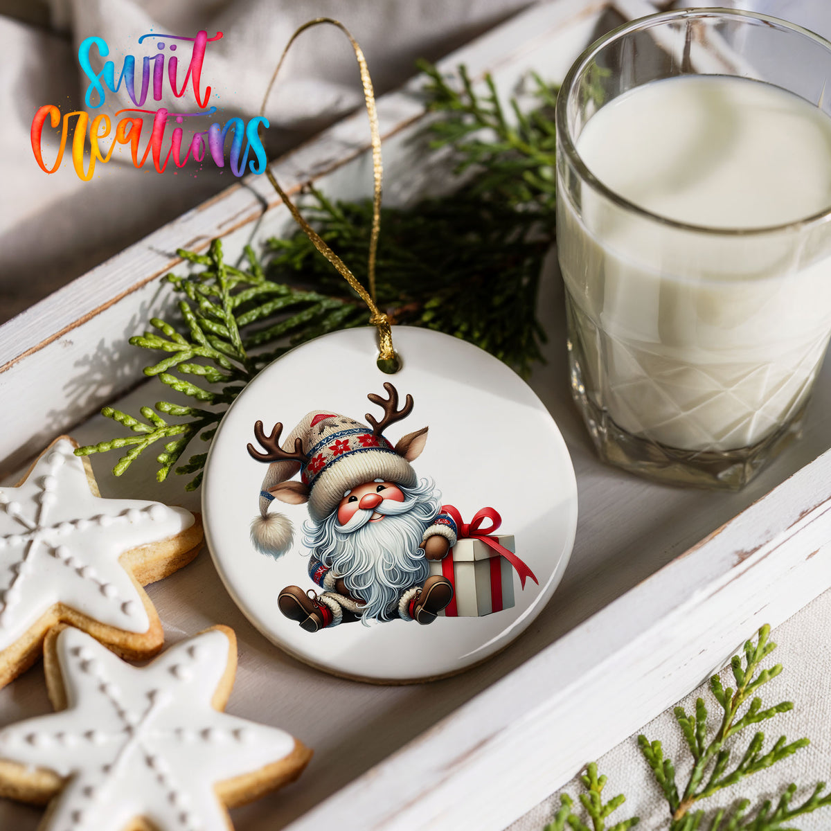 Santa sitting beside a wrapped Christmas gift ceramic Christmas ornament styled with cookies and milk