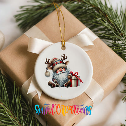 Santa sitting beside a wrapped Christmas gift ceramic Christmas ornament arranged on a wrapped Christmas gift