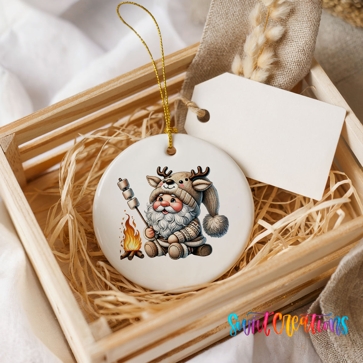 Santa roasting a marshmallow by a campfire ceramic Christmas ornament displayed in a rustic wooden gift crate