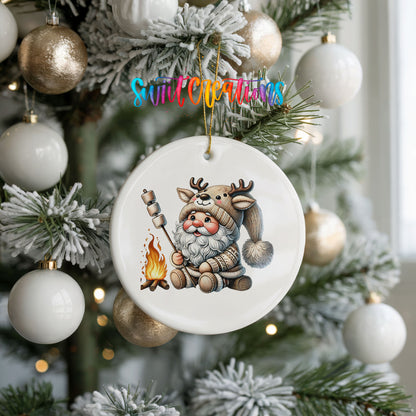 Santa roasting a marshmallow by a campfire ceramic Christmas ornament hanging on a frosted holiday tree