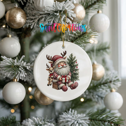 Round ceramic Christmas ornament featuring Santa with a reindeer beside a decorated Christmas tree, hanging on a frosted holiday tree
