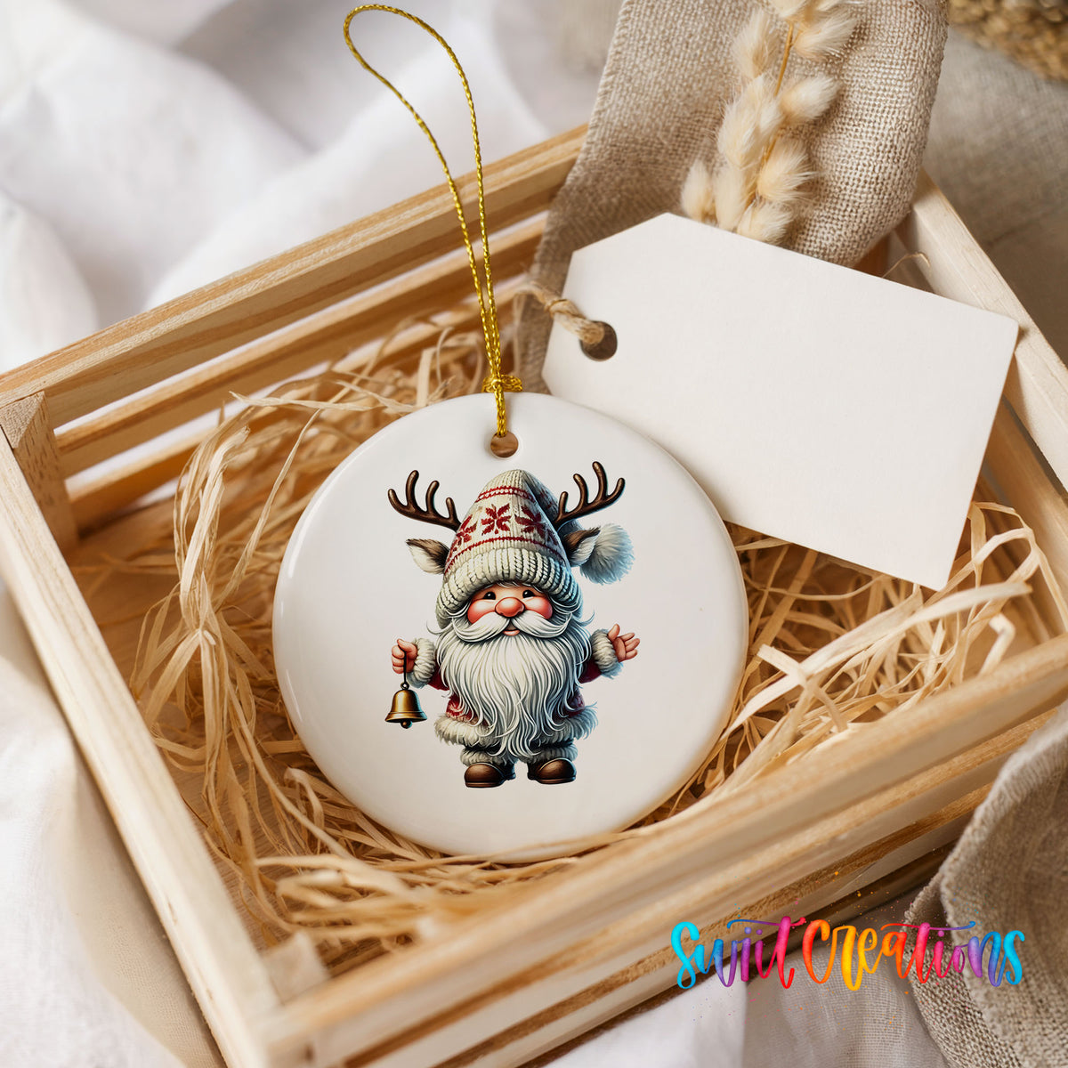 Round ceramic Christmas ornament featuring Santa ringing a Christmas handbell, presented in a rustic wooden gift crate