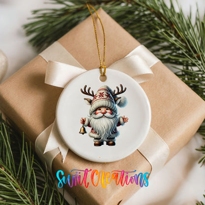 Round ceramic Christmas ornament featuring Santa ringing a Christmas handbell, placed on a wrapped Christmas gift