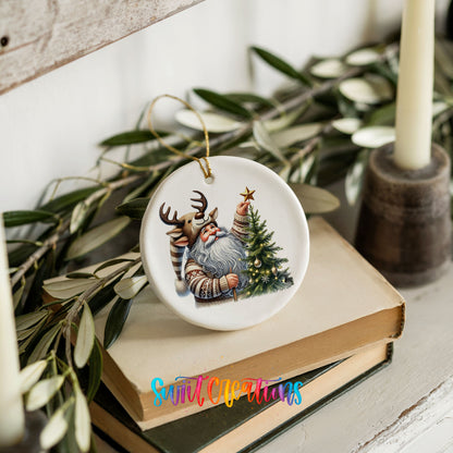 Round ceramic Christmas ornament featuring Santa placing a star on a Christmas tree, styled on books with holiday greenery