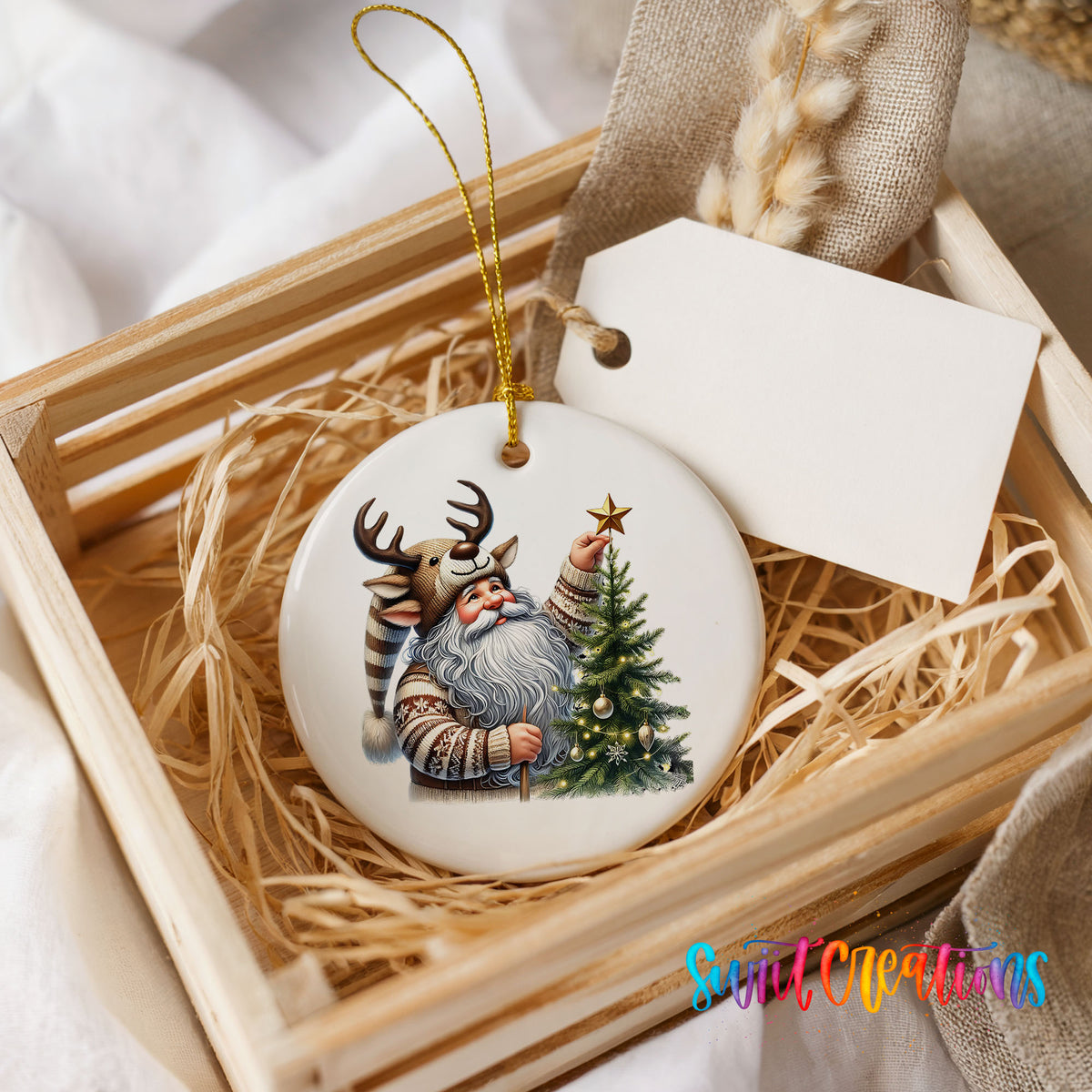 Round ceramic Christmas ornament featuring Santa placing a star on a Christmas tree, presented in a rustic wooden gift crate