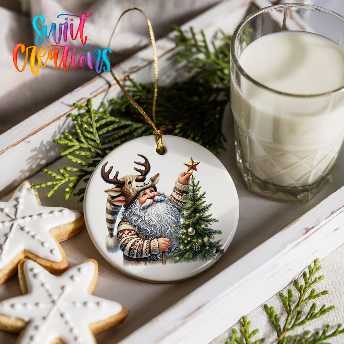 Round ceramic Christmas ornament featuring Santa placing a star on a Christmas tree, styled with cookies and milk