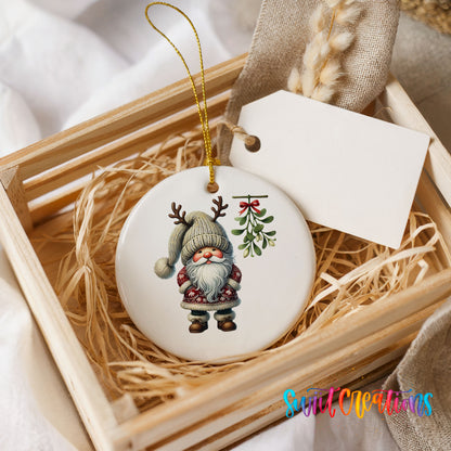 Round ceramic Christmas ornament featuring Santa standing beneath Christmas mistletoe, presented in a rustic wooden gift crate