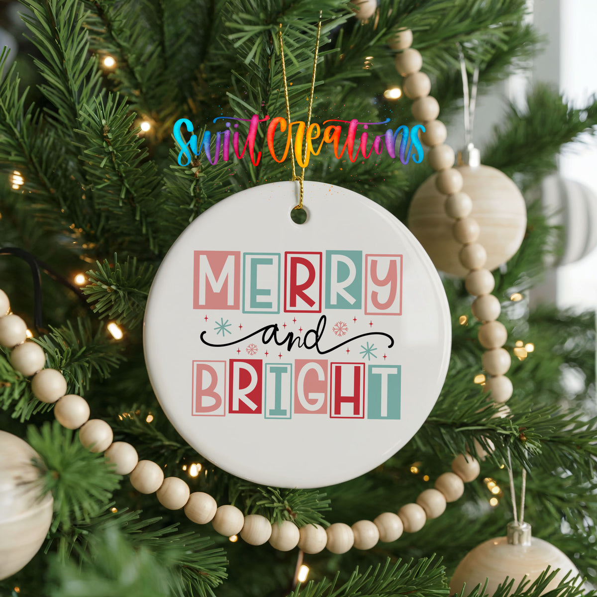 Round ceramic Christmas ornament featuring pastel block-letter Merry and Bright holiday typography, hanging on a decorated Christmas tree