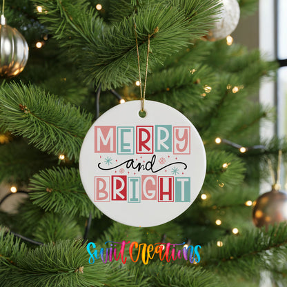 Round ceramic Christmas ornament featuring pastel block-letter Merry and Bright holiday typography, hanging on a green Christmas tree