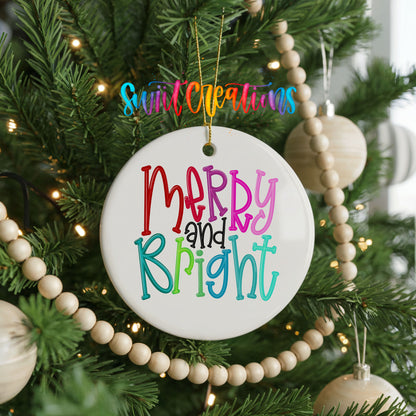 Round ceramic Christmas ornament featuring colorful hand-lettered Merry and Bright holiday typography, hanging on a decorated Christmas tree