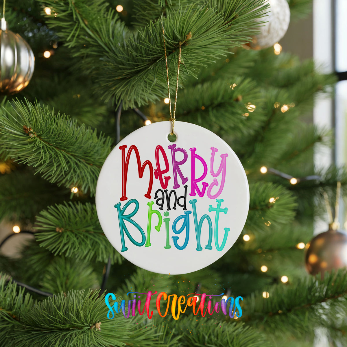 Round ceramic Christmas ornament featuring colorful hand-lettered Merry and Bright holiday typography, hanging on a green Christmas tree