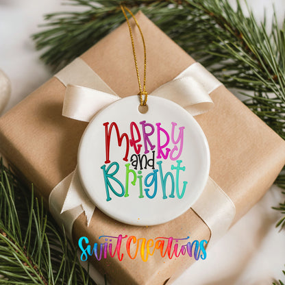 Round ceramic Christmas ornament featuring colorful hand-lettered Merry and Bright holiday typography, placed on a wrapped Christmas gift