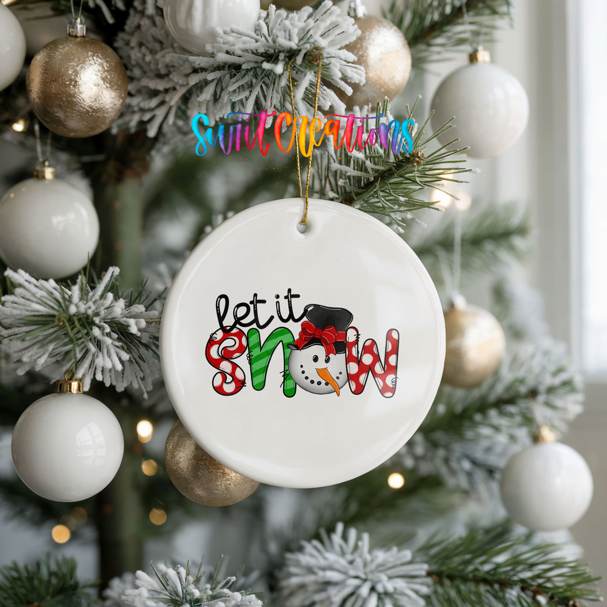 Round ceramic Christmas ornament featuring playful red and black Let It Snow holiday typography, hanging on a frosted holiday tree
