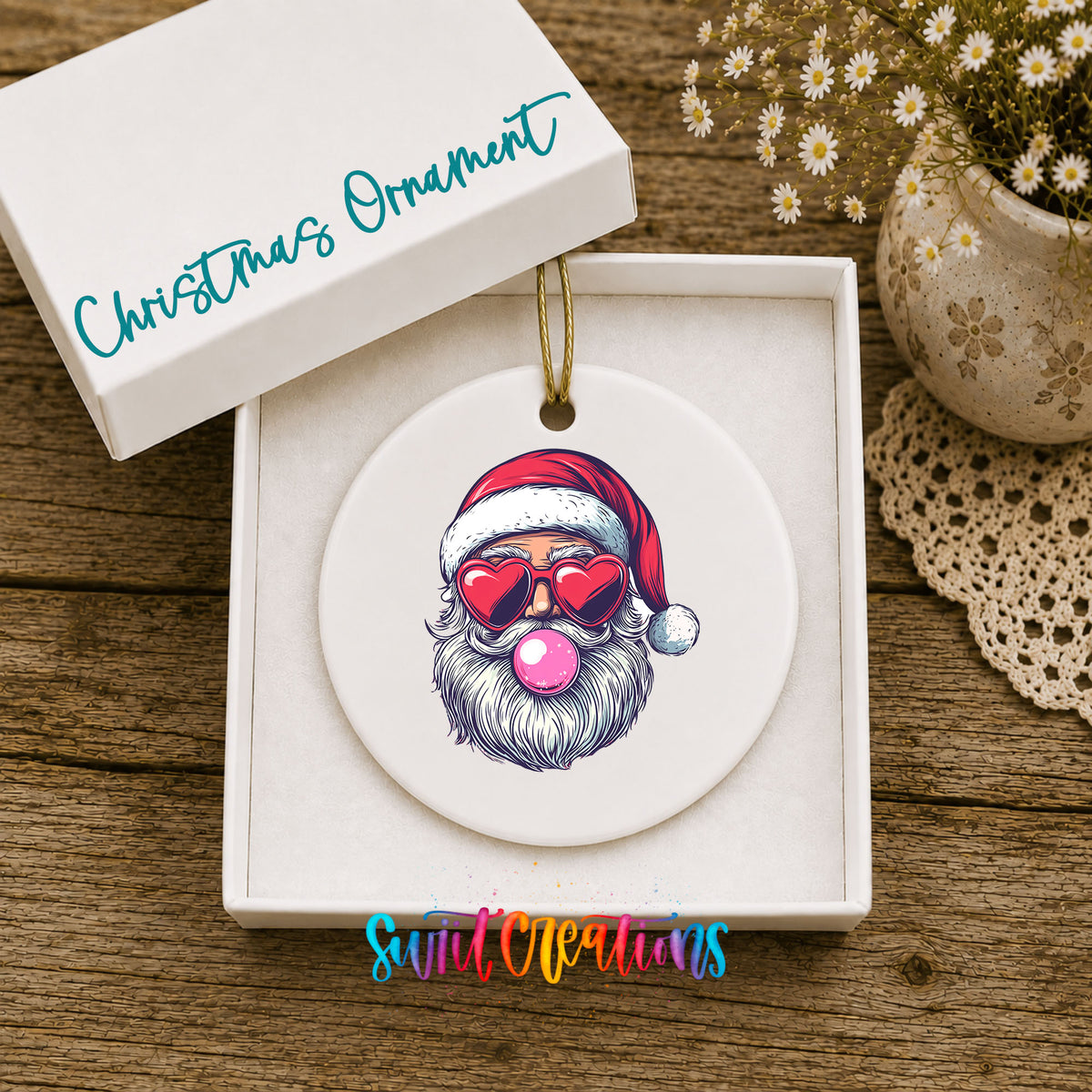 Round ceramic Christmas ornament featuring retro Santa wearing sunglasses and blowing pink bubblegum, displayed in the included gift box