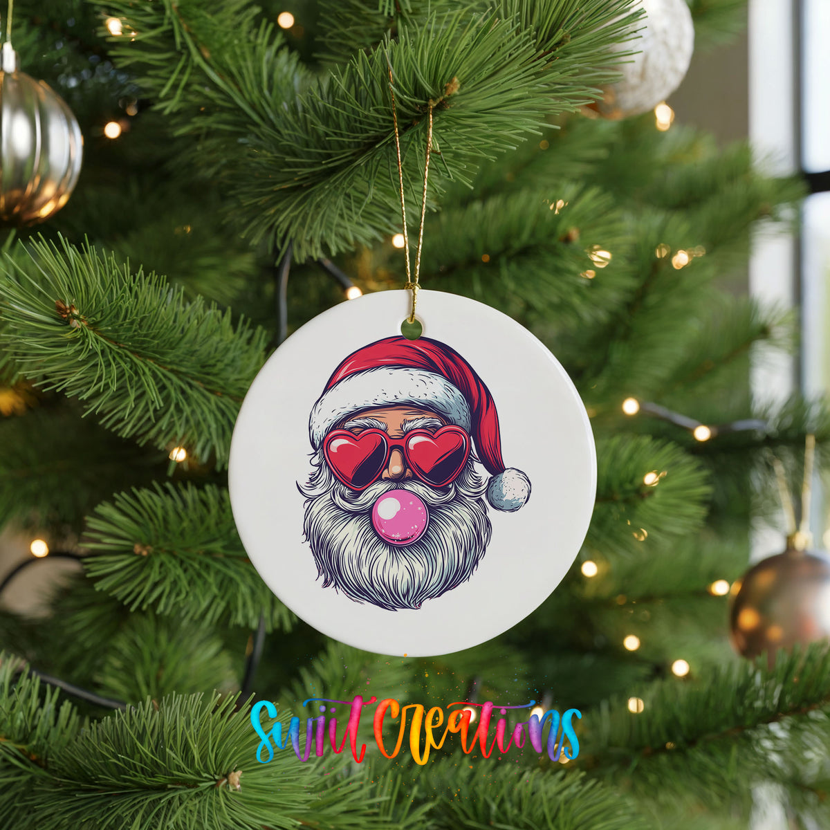 Round ceramic Christmas ornament featuring retro Santa wearing sunglasses and blowing pink bubblegum, hanging on a green Christmas tree