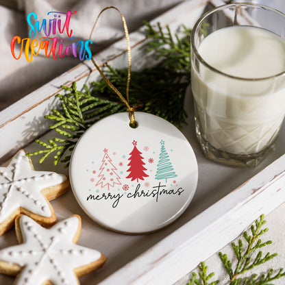 Round ceramic Christmas ornament featuring minimalist red and mint Christmas trees with Merry Christmas script, styled with cookies and milk