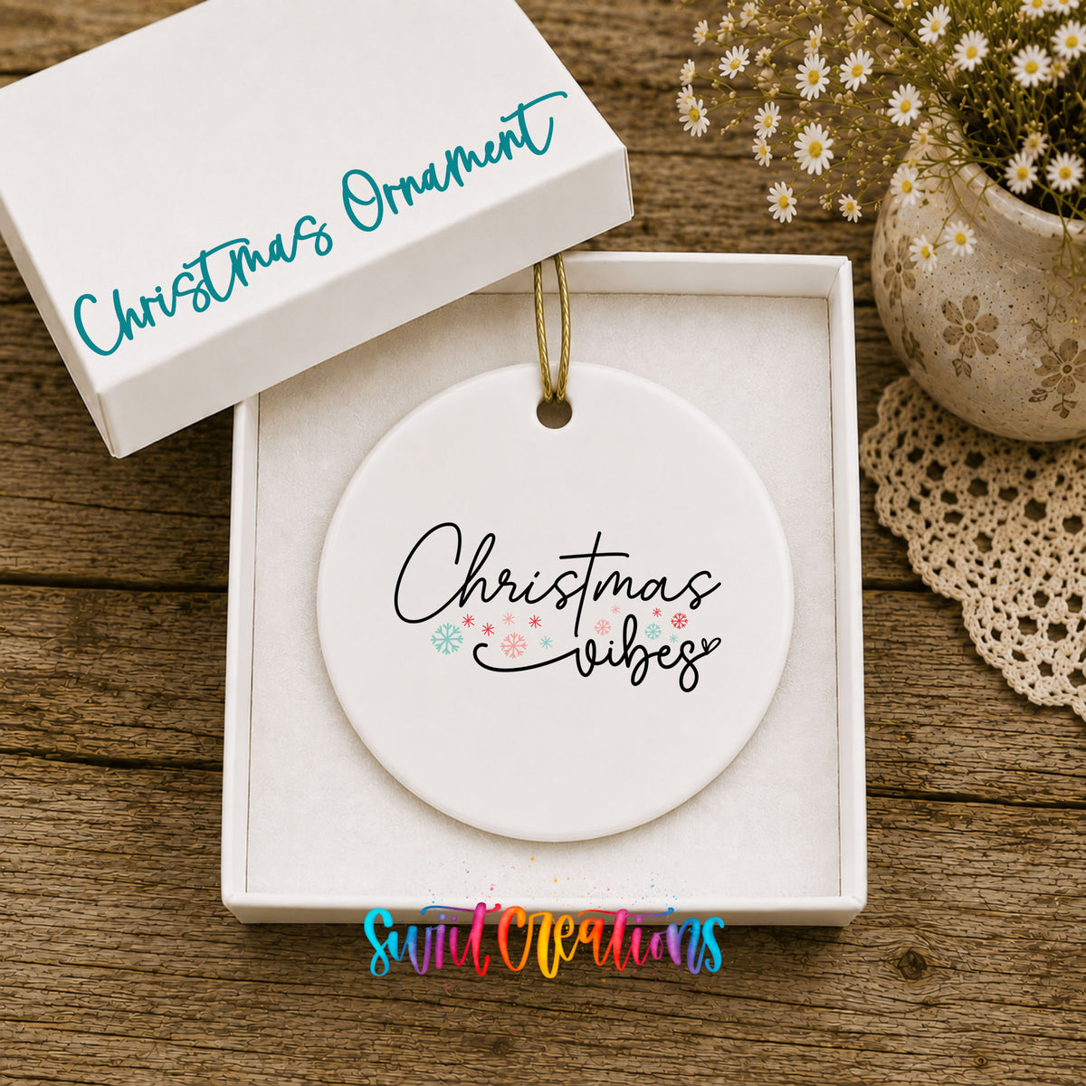 Round ceramic Christmas ornament featuring delicate Christmas Vibes script with small colorful holiday accents, displayed in the included gift box