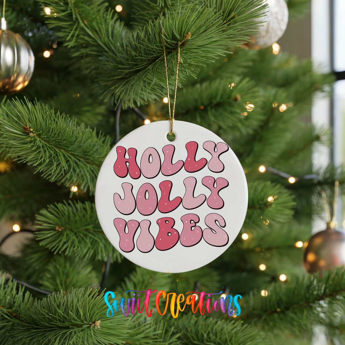 Round ceramic Christmas ornament featuring pink retro Holly Jolly Vibes typography, hanging on a green Christmas tree