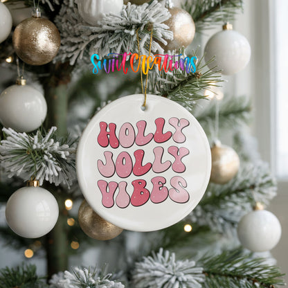 Round ceramic Christmas ornament featuring pink retro Holly Jolly Vibes typography, hanging on a frosted holiday tree