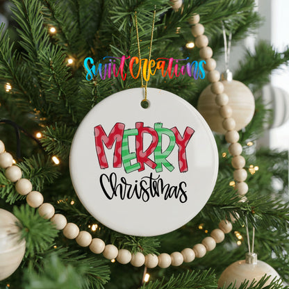 Round ceramic Christmas ornament featuring colorful patterned Merry Christmas typography, hanging on a decorated Christmas tree
