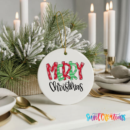 Round ceramic Christmas ornament featuring colorful patterned Merry Christmas typography, styled with elegant holiday table decor