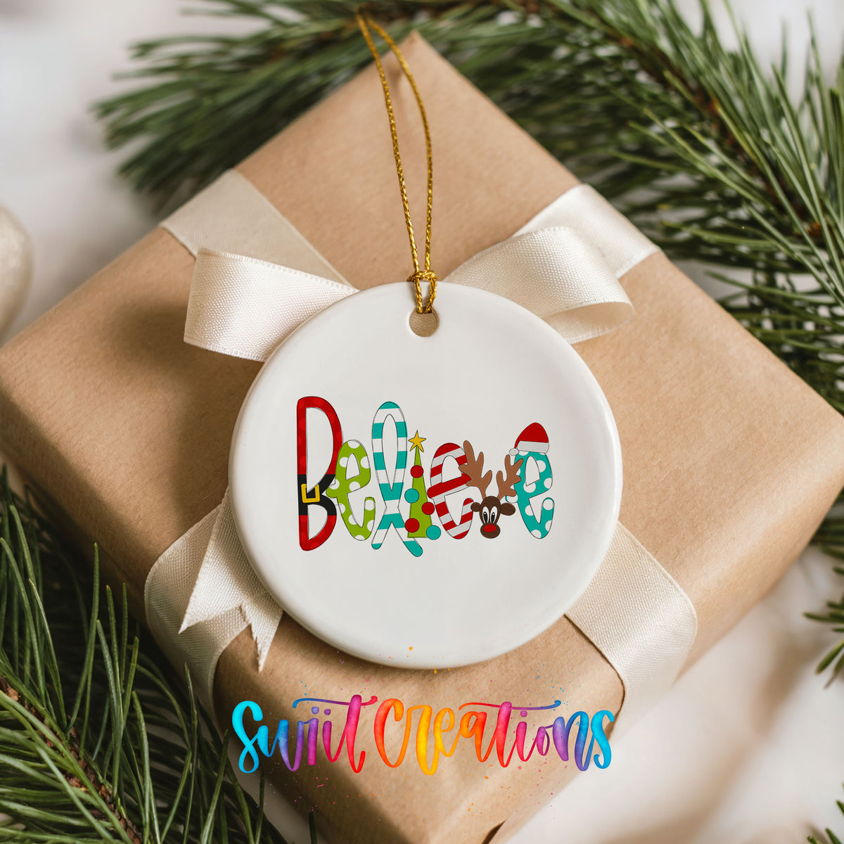 Round ceramic Christmas ornament featuring colorful whimsical Believe holiday lettering, placed on a wrapped Christmas gift