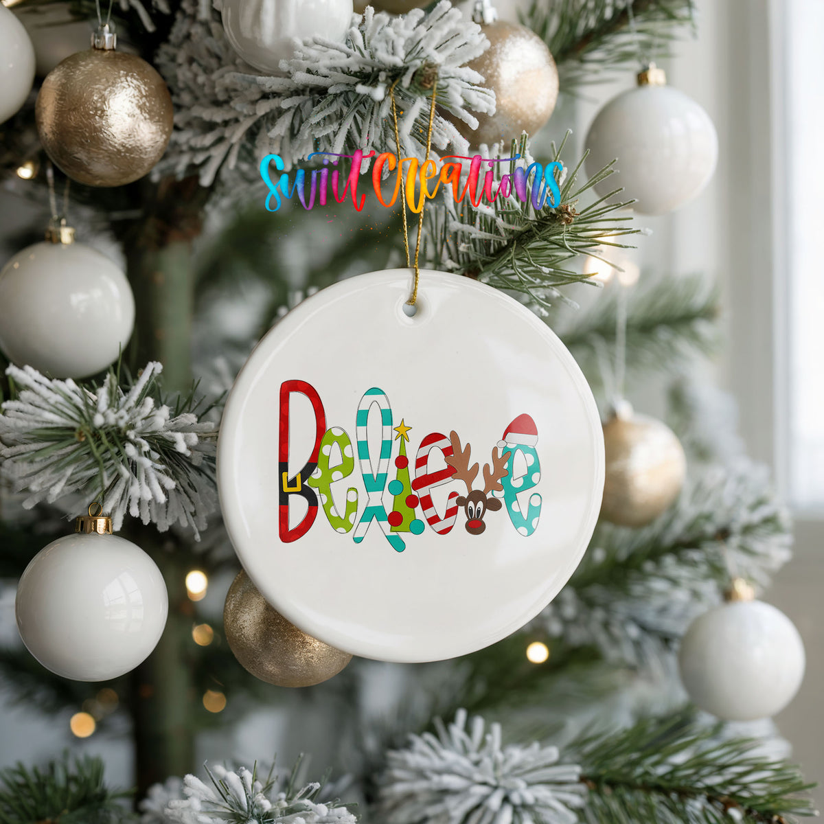 Round ceramic Christmas ornament featuring colorful whimsical Believe holiday lettering, hanging on a frosted holiday tree
