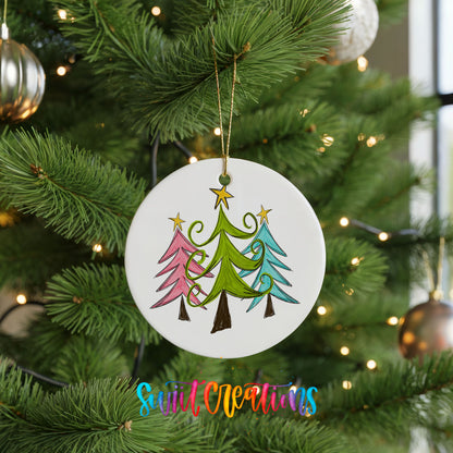 Round ceramic Christmas ornament featuring three colorful whimsical Christmas trees, hanging on a green Christmas tree