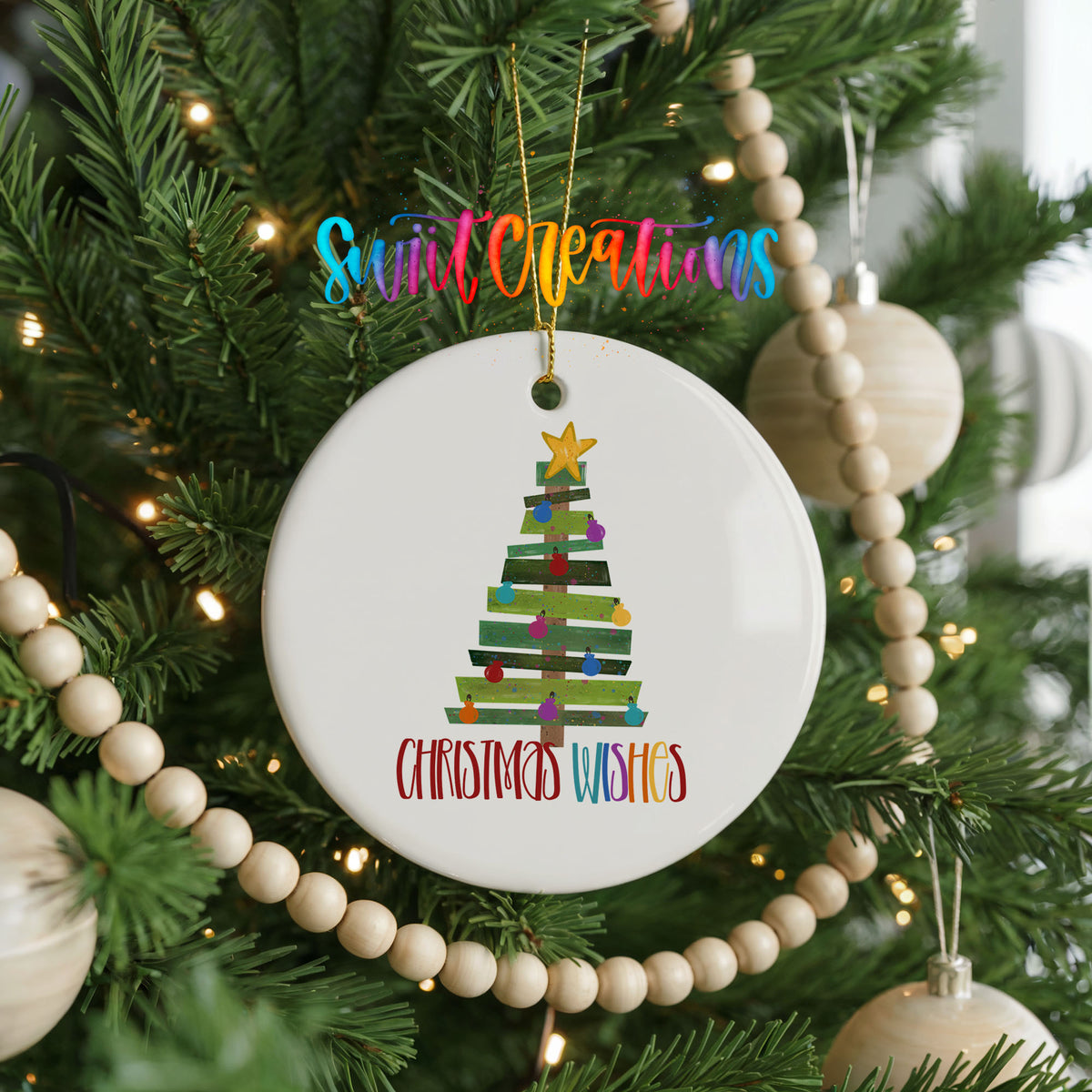 Round ceramic Christmas ornament featuring colorful pallet-style Christmas tree with Christmas Wishes lettering, hanging on a decorated Christmas tree