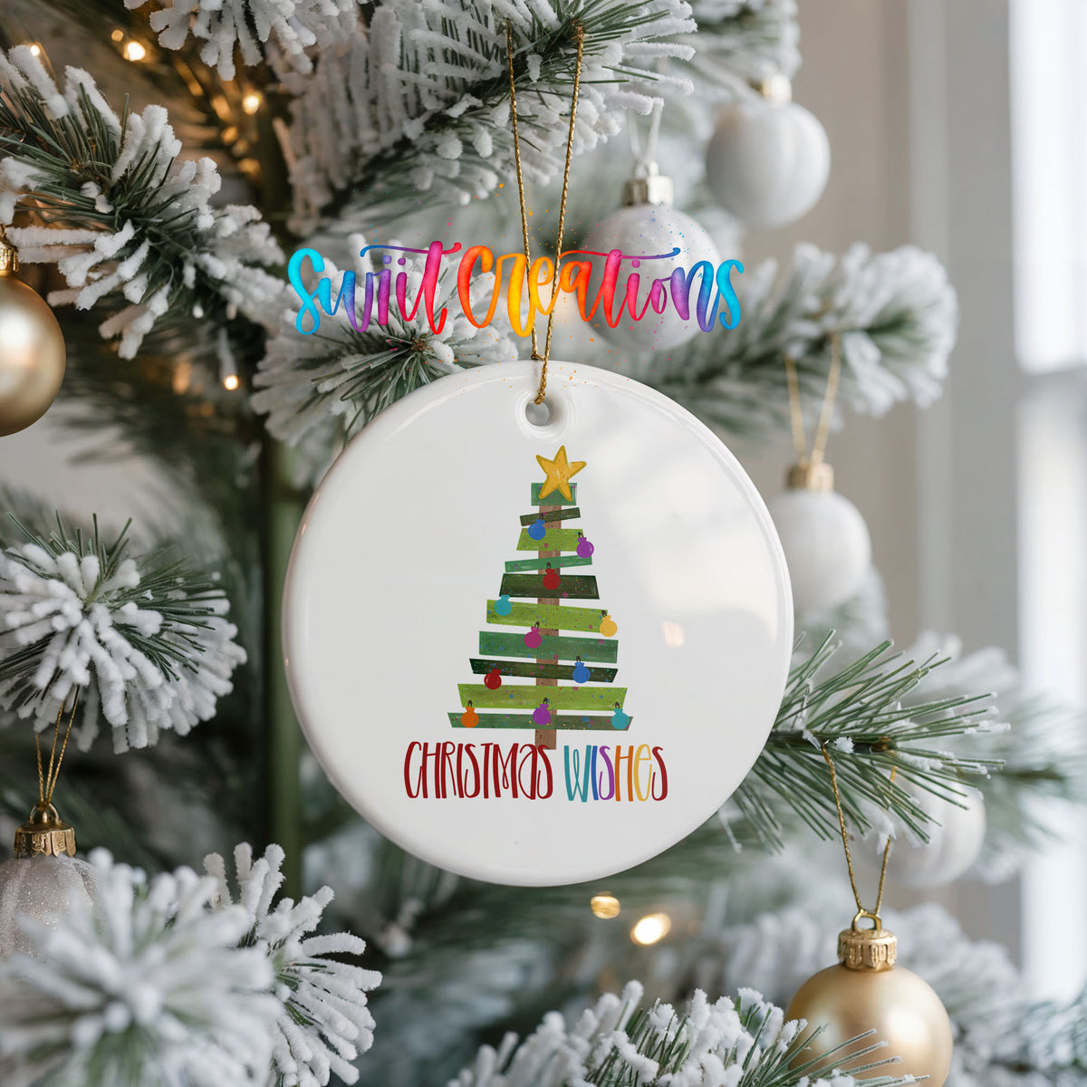 Round ceramic Christmas ornament featuring colorful pallet-style Christmas tree with Christmas Wishes lettering, hanging on a frosted Christmas tree