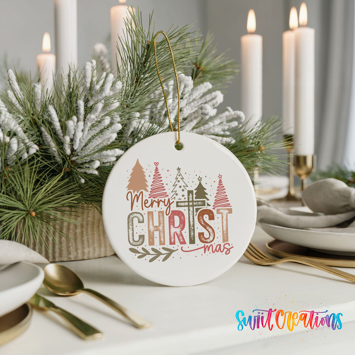 Round ceramic Christmas ornament featuring Merry Christmas typography with a pastel winter village and trees, styled with elegant holiday table decor
