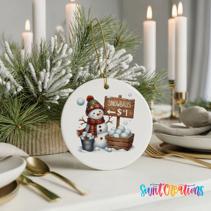 Round ceramic Christmas ornament featuring cheerful snowman selling snowballs for five cents, styled with elegant holiday table decor