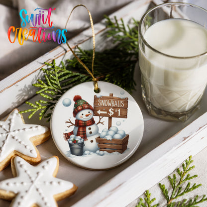 Round ceramic Christmas ornament featuring cheerful snowman selling snowballs for five cents, styled with cookies and milk