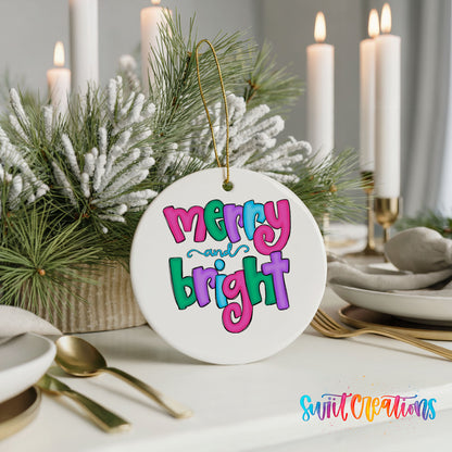 Round ceramic Christmas ornament featuring bright groovy Merry and Bright lettering in pink teal and purple, styled with elegant holiday table decor