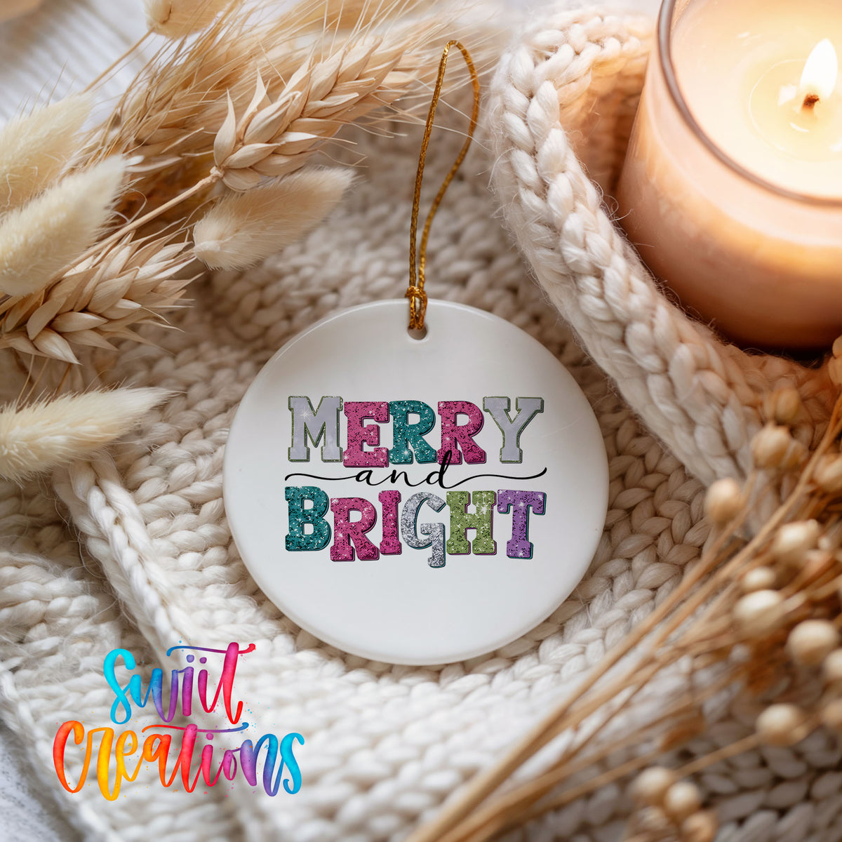 Round ceramic Christmas ornament featuring distressed patchwork Merry and Bright holiday typography, styled beside a candle and cozy knit blanket