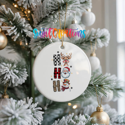 Round ceramic Christmas ornament featuring stacked Ho Ho Ho lettering with cheerful holiday characters, hanging on a frosted Christmas tree