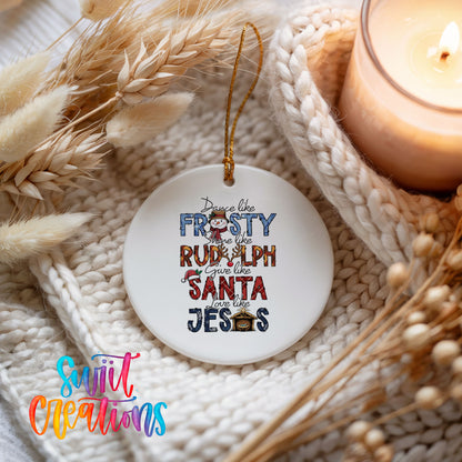 Round ceramic Christmas ornament featuring Dance like Frosty ride like Rudolph give like Santa love like Jesus message, styled beside a candle and cozy knit blanket