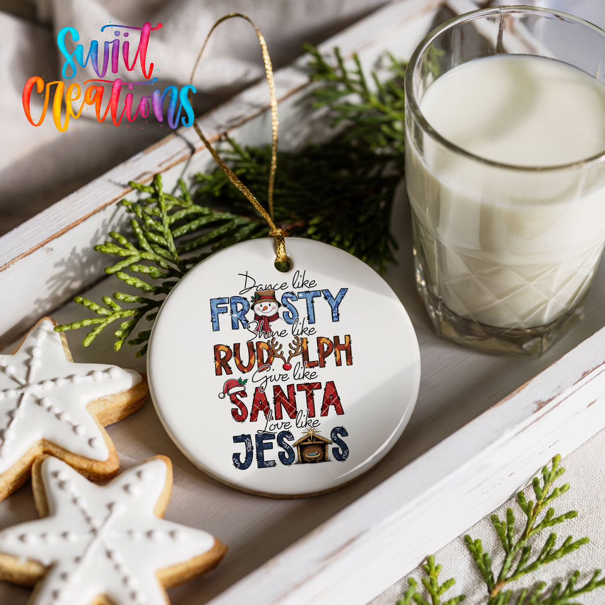 Round ceramic Christmas ornament featuring Dance like Frosty ride like Rudolph give like Santa love like Jesus message, styled with cookies and milk