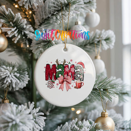 Round ceramic Christmas ornament featuring festive patterned Mama lettering with a large red holiday bow, hanging on a frosted Christmas tree
