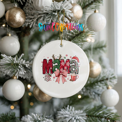 Round ceramic Christmas ornament featuring festive patterned Mama lettering with a large red holiday bow, hanging on a frosted holiday tree