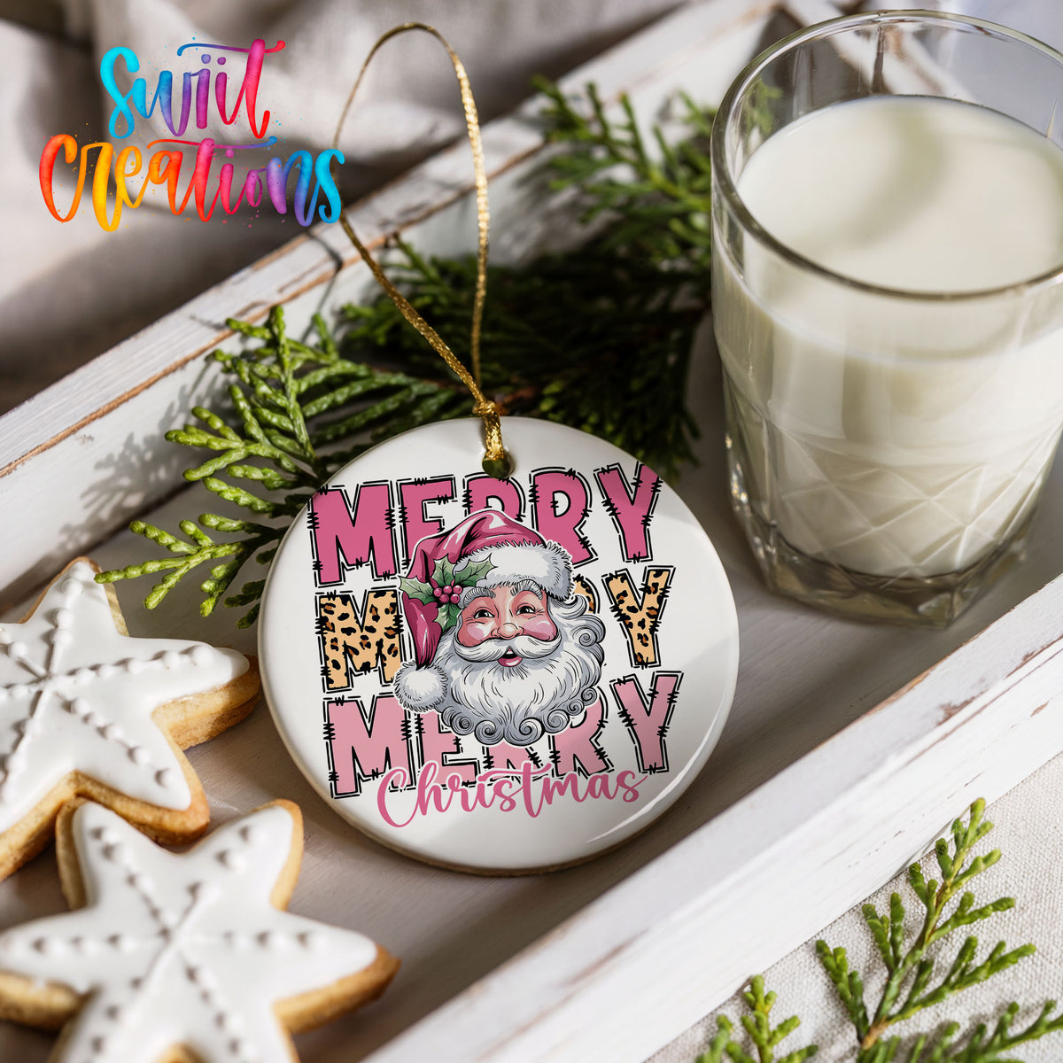 Round ceramic Christmas ornament featuring stacked Merry Merry Merry Christmas lettering with Santa and leopard print accents, styled with cookies and milk